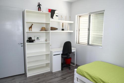 a bedroom with a bed and a desk and shelves at Salt Lake view Apartment in Larnaca
