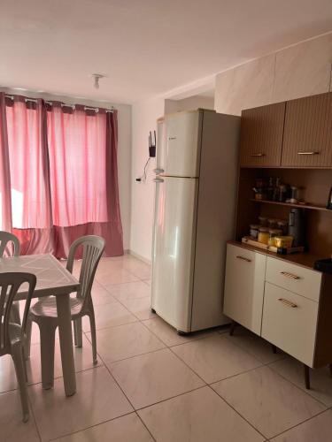 a kitchen with a table and a white refrigerator at Apartamento Jampa in João Pessoa