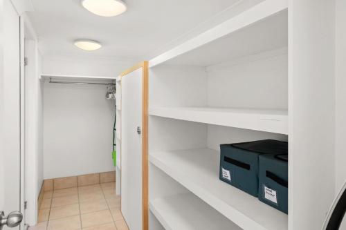a room with white shelves and a door with a box at Bayview Cottage Waterfront Soldiers Point in Soldiers Point