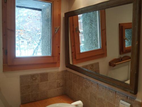 La salle de bains est pourvue d'un miroir, de toilettes et d'une fenêtre. dans l'établissement Studio au pied des pistes, centre Val d'Isère, 3 pers, cosy mezzanine, cuisine équipée, WiFi - FR-1-519-37, à Val dʼIsère