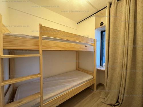 - deux lits superposés dans une petite chambre dans l'établissement Location cosy avec Wi-Fi et parking couvert aux Angles - FR-1-295-208, aux Angles