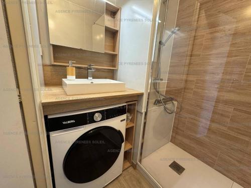 La petite salle de bains est pourvue d'un lavabo et d'un lave-linge. dans l'établissement Location cosy avec Wi-Fi et parking couvert aux Angles - FR-1-295-208, aux Angles