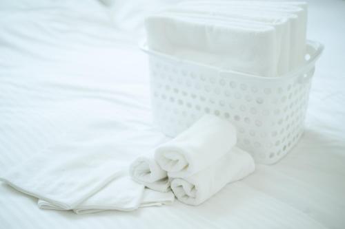 a basket of white towels and a napkin at CleanNest Hokkaido Chitose in Chitose