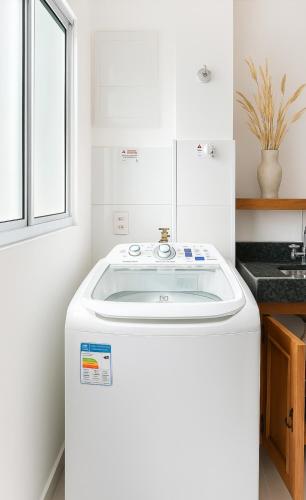 a white sink in a kitchen with a window at Apto Prox Parque do Sabia e Aeroporto in Uberlândia
