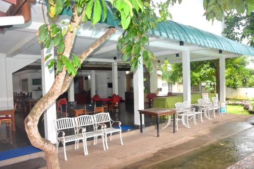 a group of chairs and tables under a building at Hotel Romi Gampaha in Gampaha