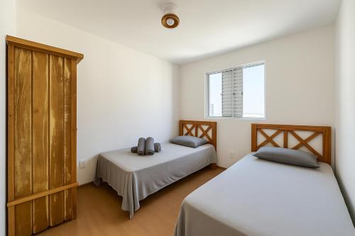 a bedroom with two beds and a window at Apto Prox Parque do Sabia e Aeroporto in Uberlândia