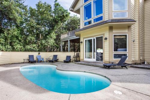 a house with a swimming pool in front of a house at 3050 - Whispering Pines in Southern Shores