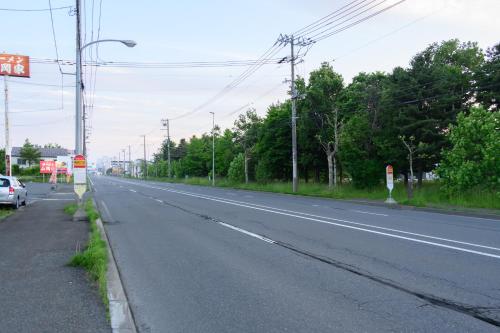 an empty road with a car parked on the side at CleanNest Hokkaido Chitose in Chitose