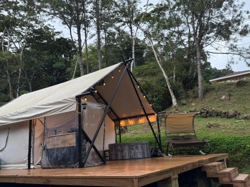 a tent on a wooden table with a chair at Safari Glamping By Ohana Green Home in Alto del Mamey