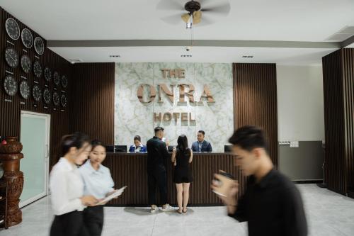a group of people standing in front of a lobby at The ONRA Hotel in Phnom Penh