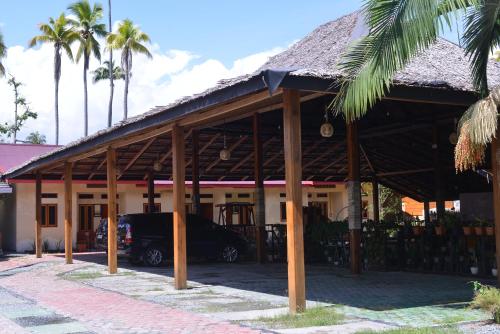 a house with a car parked in front of it at Homestay & Resto 88 in Dondo