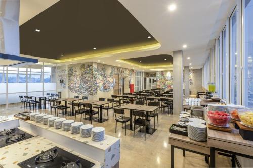 a restaurant with tables and chairs in a room at Amaris Hotel Lampung City in Kuala