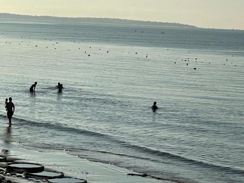 a group of people in the water at the beach at HAVANA Beach & Pool Villa - Mui Ne,Phan Thiet in Mui Ne