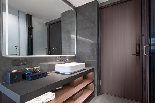 a bathroom with a sink and a mirror at Yuanshe Yiju Hotel in Chengdu