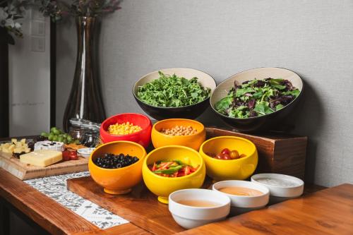 a group of bowls of vegetables on a table at Hotel Traveltine in Singapore