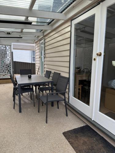 a patio with a table and chairs and a window at Courthouse - Family Retreat Near Bendigo CBD in Bendigo