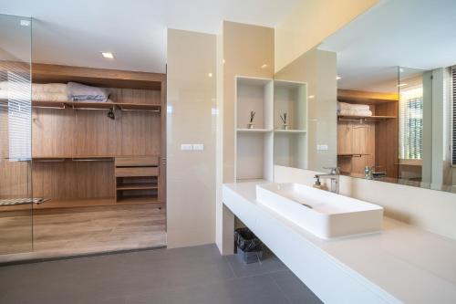 a bathroom with a sink and a mirror at Modern Minimalist 6 Bedroom Light Luxury Villa Private Pool Golf Course Laguna Park in Ban Phru Champa