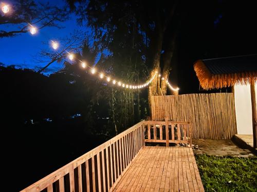 a wooden bench sitting on a fence with lights at Private Mountain River Cabin in Daraitan Tanay Rizal Philippines in Tanay