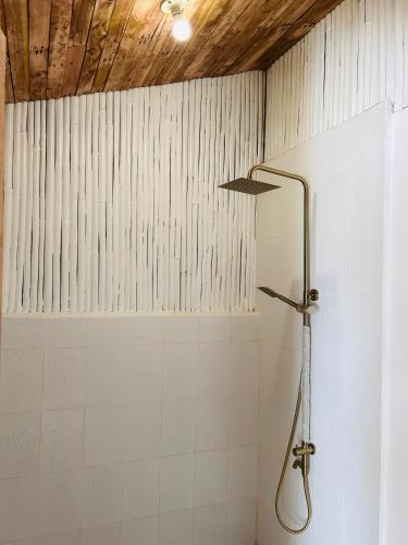 a shower in a bathroom with white tiles at Private Mountain River Cabin in Daraitan Tanay Rizal Philippines in Tanay