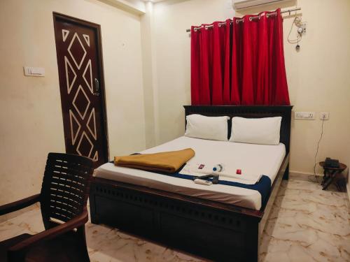 a bedroom with a bed with a red curtain at The Fortune inn in Chennai