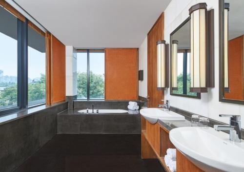a bathroom with two sinks and two mirrors at The Westin Xi'an in Xi'an