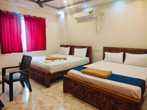 a room with two beds and a chair in it at The Fortune inn in Chennai