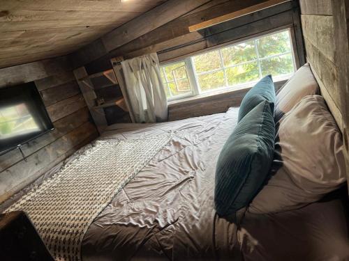 a bed in a small room with a window at Rustic Guesthouse in Sayward