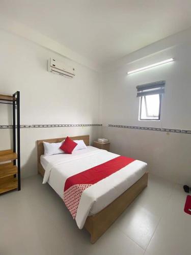 a white bedroom with a bed with a red blanket at LUXURY Motel in Da Nang