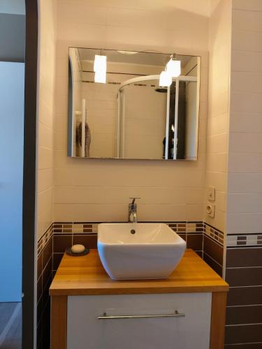 une salle de bain avec un lavabo blanc et un miroir dans l'établissement Charmant Appartement proche mer et centre, calme, 4 pers, à Cabourg