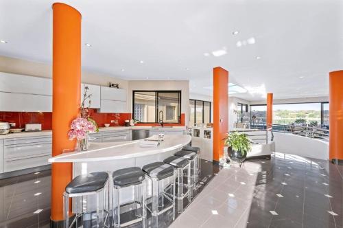 a kitchen with orange columns and a counter with stools at Luxury 6beds Waterfront Retreat in Sydney