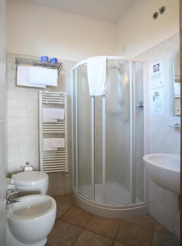 a bathroom with a shower and a toilet and a sink at Hotel Aurora in San Vincenzo