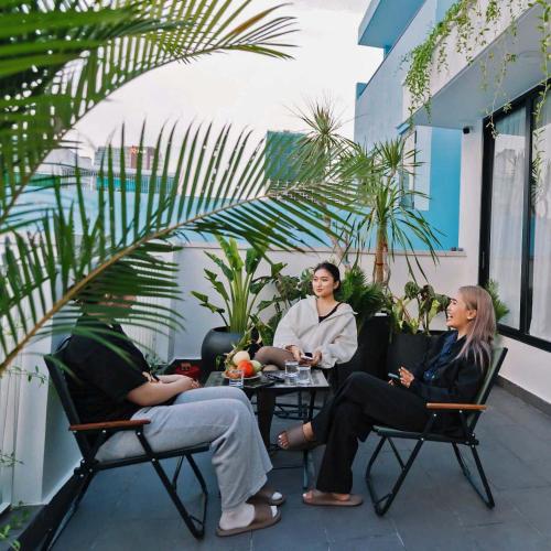 a group of people sitting around a table on a patio at EL Where Hotel in Ho Chi Minh City