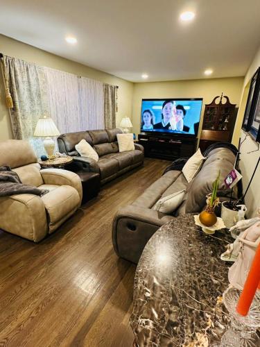 a living room with two couches and a flat screen tv at The Peaceful Perch Retreat Near NYC Elle's Home in Trenton
