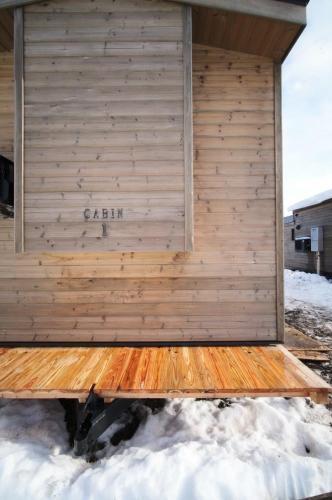 a building with a wooden wall in the snow at The Lake Side Inn in Shinano