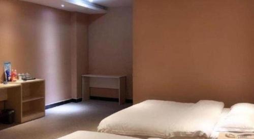 Postel nebo postele na pokoji v ubytování Kunming Tong Yi Business Hotel