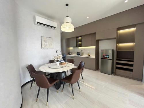 una cucina e una sala da pranzo con tavolo e sedie di VIERA Novaworld Phan Thiet Golf Villa a Phan Thiet
