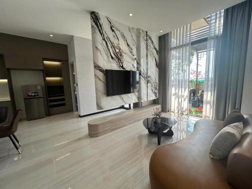 un soggiorno con divano e TV a schermo piatto di VIERA Novaworld Phan Thiet Golf Villa a Phan Thiet