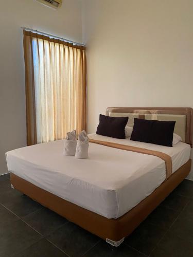 a bedroom with a large bed with two pillows at Kubu Jimbaran in Jimbaran