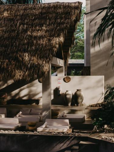 a room with vases and a straw roof at Esh Hotel & Spa in Nosara