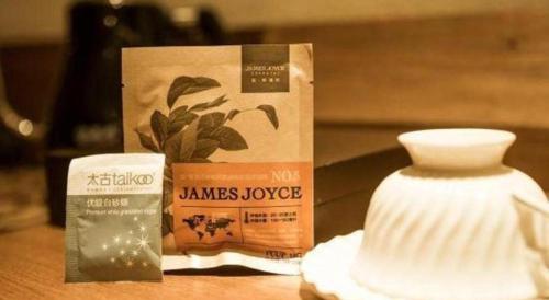 a box of janes hospice and a vase on a table at James Joyce Coffetel Qufu Tourist Center Gulou Street Sankong Scenic Spot in Jining