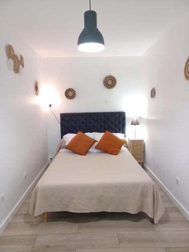 ein Schlafzimmer mit einem Bett mit orangefarbenen Kissen in der Unterkunft Villa Padulina au bord de la mer avec piscine in Galeria