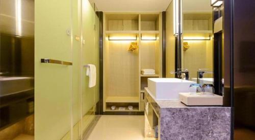 a bathroom with a sink and a mirror at Echarm Hotel Anshun High-speed Railway Station Jichang Road in Anshun