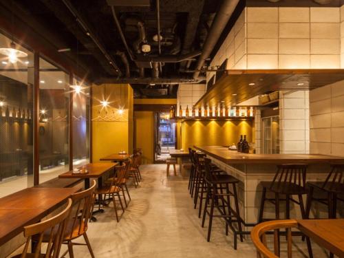 a restaurant with wooden tables and chairs and a bar at APA Hotel Ginza Kyobashi Tokyo Eki Yaesu Minamiguchi in Tokyo