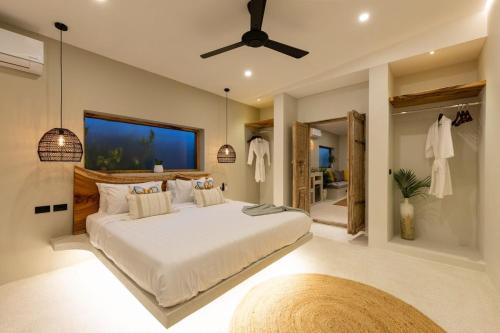 a bedroom with a large bed with a ceiling fan at 3min walk to the beach, night market, restaurant, Humble House 2 in Amphoe Koh Samui