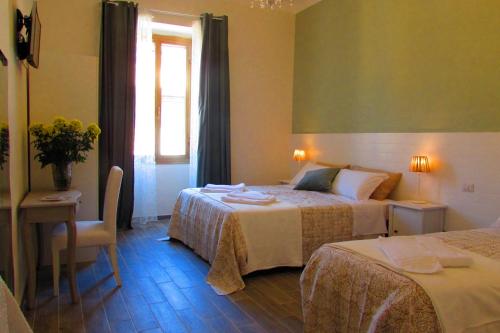 ローマにあるTermini Guesthouseのベッド2台と窓が備わるホテルルームです。