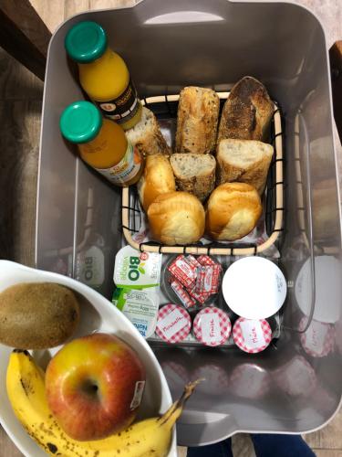 Una lonchera con pan y una manzana y un tazón de comida. en La Charmille - Côté Cour, en La Copechagnière