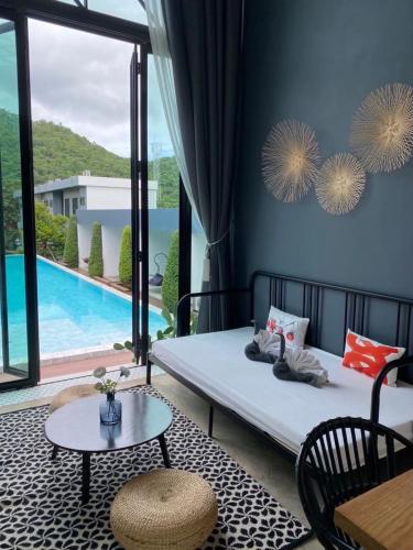 a bedroom with a bed with a view of a pool at Adoor hotel Khao Yai in Ban Rai
