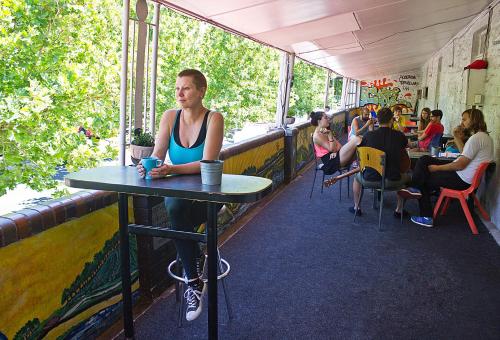 a woman sitting at a table in a restaurant at Adelaide Travellers Inn Backpackers Hostel in Adelaide