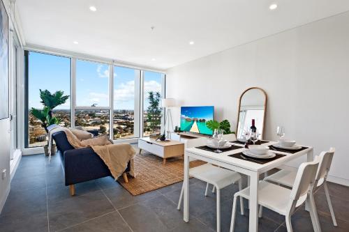 a living room with a white table and chairs at Breathtaking Views Modern 2BR Pool, Parking, Gym in Sydney