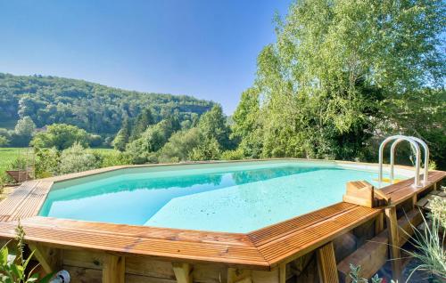 a large swimming pool with a wooden deck around it at Cozy Home In Les Eyzies in Les Eyzies-de-Tayac